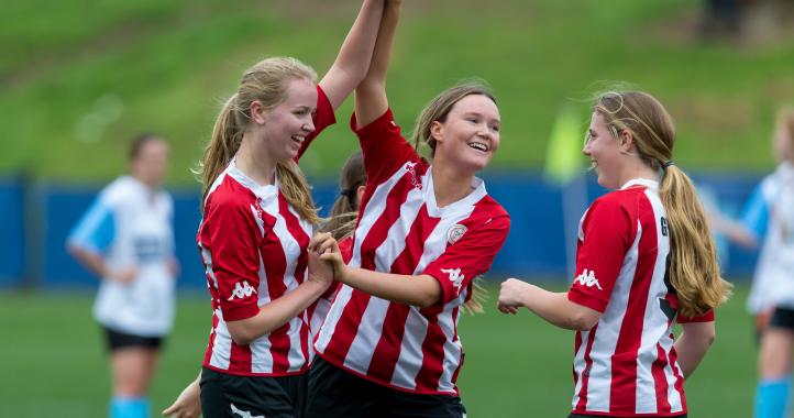 Girls playing soccer celebrating